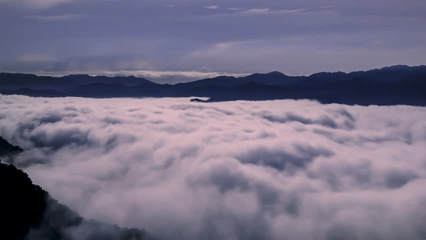 A serene scene of a full moon illuminating a vast sea of clouds, resembling ocean waves. The sky is dotted with stars, adding to the tranquil ambiance. Xindian District, Taiwan.