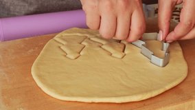 Female hands cutting out the rolled sugar Christmas fir tree shape cookies with cookie cutter close up - Powered by Shutterstock - Get 15% off with code: PIKWIZARD15