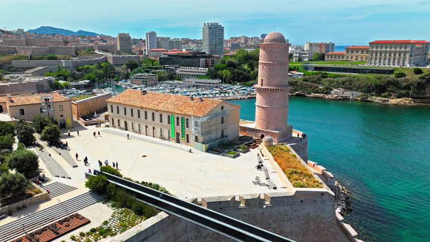 Aerial view of a fortress with a bridge leading to a regional history museum in Marseille, France. Scenic view of coastal area of Marseille overlooking medieval Fort Saint-Jean and Old Port.