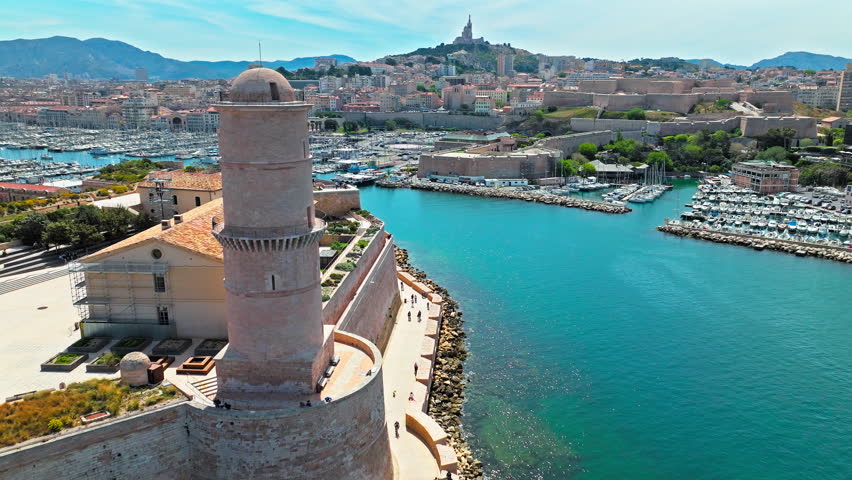Aerial view of a fortress with a bridge leading to a regional history museum in Marseille, France. Scenic view of coastal area of Marseille overlooking medieval Fort Saint-Jean and Old Port.
