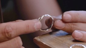 The jeweler, with the help of special hand tools, processes the jewelry: saws, polishes, gives shape, brings to an ideal condition wedding rings made of gold, silver or other precious metals - Powered by Shutterstock - Get 15% off with code: PIKWIZARD15