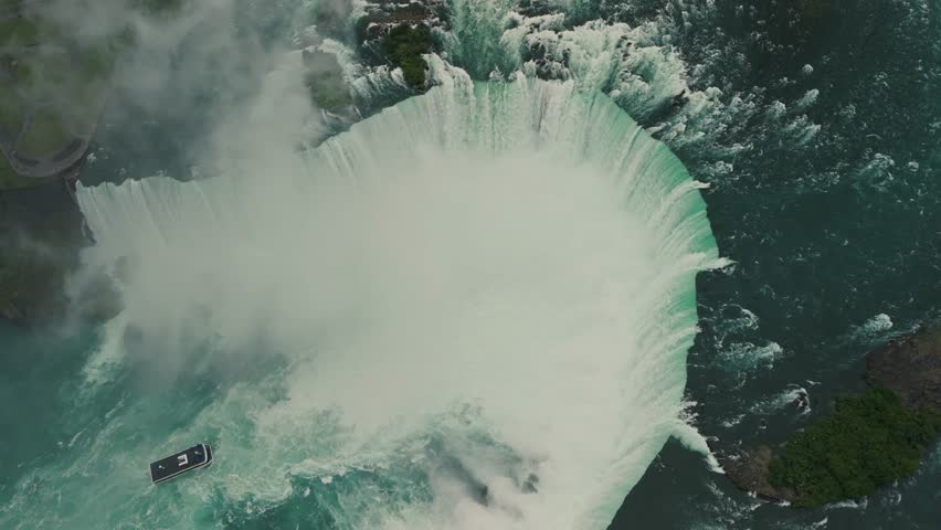 Top View. A cinematic aerial view of Niagara Falls enveloped in clouds. The footage showcases the impressive scale and beauty of the falls, enhanced by the moody weather conditions. Canada