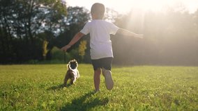 Child and dog is running on the grass. Happy pet fun concept. A dog is running around in a park with kids. A kid and a child are running on the grass near lifestyle a dog. - Powered by Shutterstock - Get 15% off with code: PIKWIZARD15
