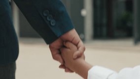 Strong hand of father holds tiny hand of schoolboy tightly. Loving father walks small son to school and listens attentively as boy in school uniform describes plans for weekend - Powered by Shutterstock - Get 15% off with code: PIKWIZARD15