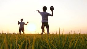 happy dad playing rugby with his son. dad throws a rugby ball to his son. family playing American football at golden hour in the park. - Powered by Shutterstock - Get 15% off with code: PIKWIZARD15