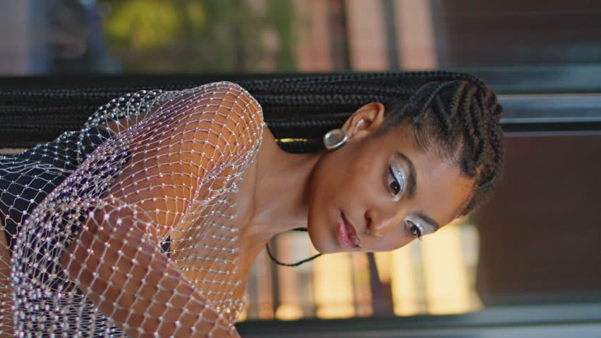 Pretty happy woman making selfie on glass wall view vertically oriented closeup. Stylish dark skin girl using smartphone taking picture herself on weekend. Smiling brunette posing with takeaway coffee