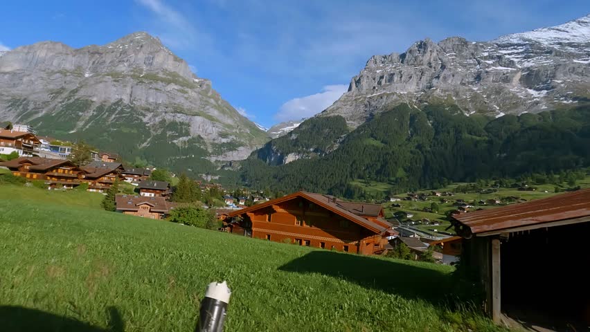A beautiful shot from a car of a town in a green landscape under the clouds