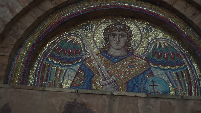 Kyiv, Ukraine - 08, July, 2021: painting angel in form young man, with wings and a sword in his hand from a colored mosaic on the wall of a long standing Orthodox church