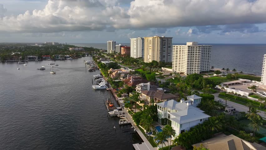 Sunset time with luxury mansions and private pier and ocean with downtown in background. Aerial orbit wide shot. Boca Raton, Florida, USA. Aerial orbit wide shot.