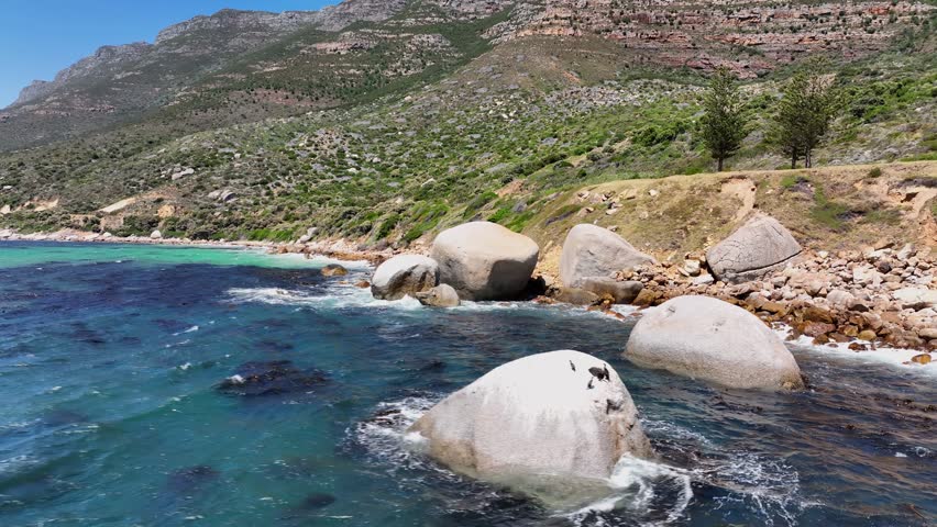 An aerial view of the sea and green-covered rocky cliffs near Cape point in South Africa