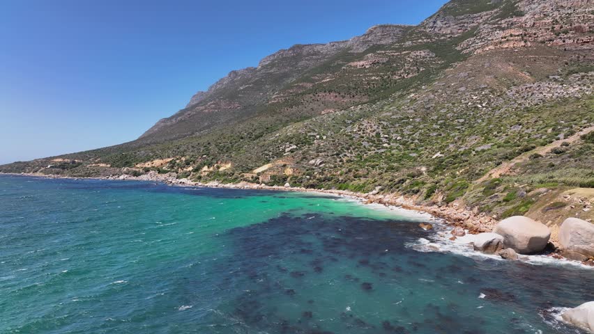 An aerial view of the sea and green-covered rocky cliffs near Cape point in South Africa
