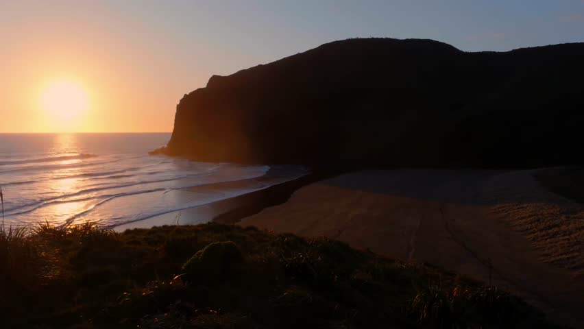 Ocean beach and headland at sunset. Anawhata, Piha, Auckland, New Zealand.