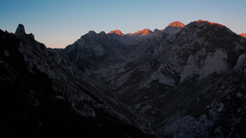 Beautyful aerial view of the Picos de Europa at sunrise. The first rays of sunlight gently kiss the rugged peaks and illuminate the lush valleys below