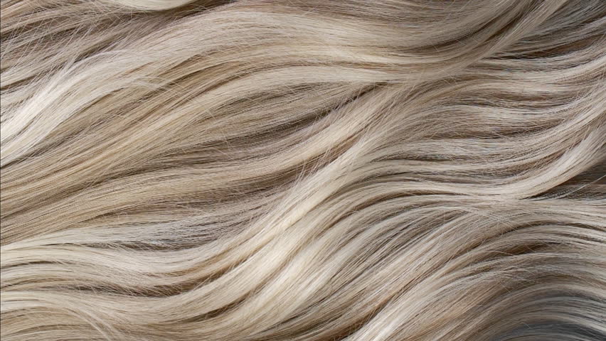 Closeup blond hair texture, slow motion of female hand combing long curly hair