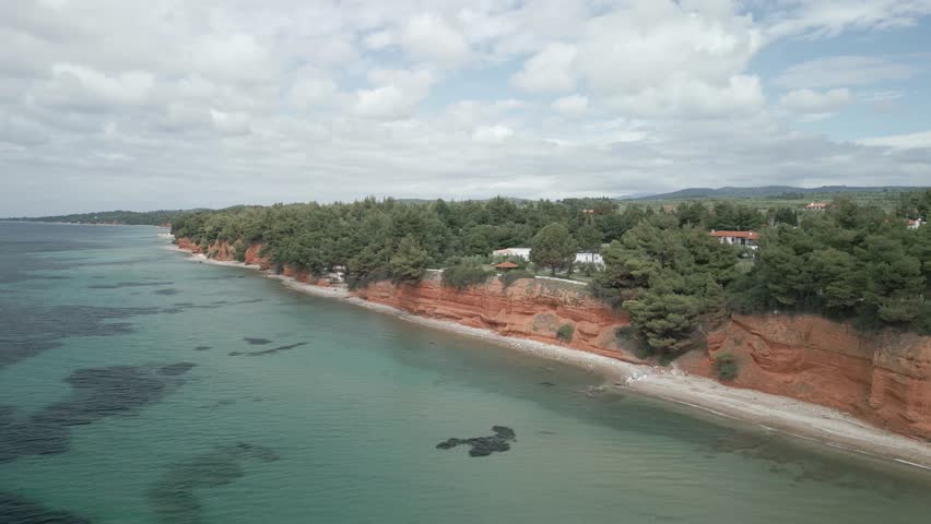 A drone footage of Red Rocks Of Metamorphosis with seascape and green landscape in Greece