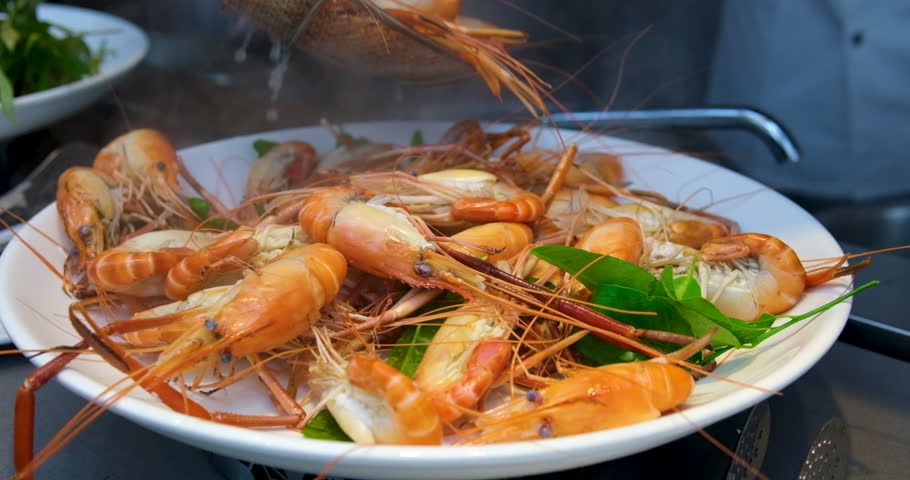boiled shrimp Steamed shrimp with lemon and herbs. Seafood, shellfish. Place shrimp on a white plate.