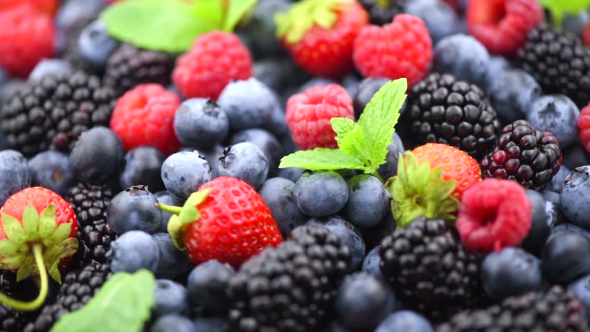 Fresh Berries. Various colorful berries rotating background. Mint leaves, Strawberry, Raspberry, Blackberry, Blueberry close-up rotating backdrop. Fresh Bio Fruits, Healthy eating, diet.