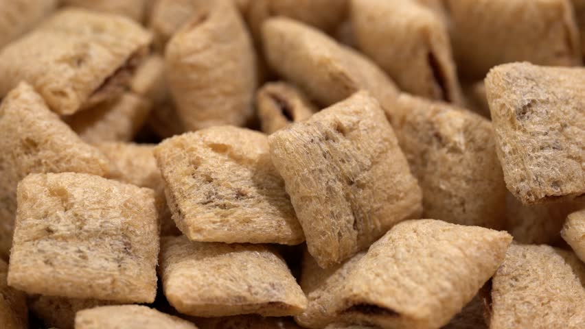 Corn snack. Cereal pads with filling falling into bowl against white background
