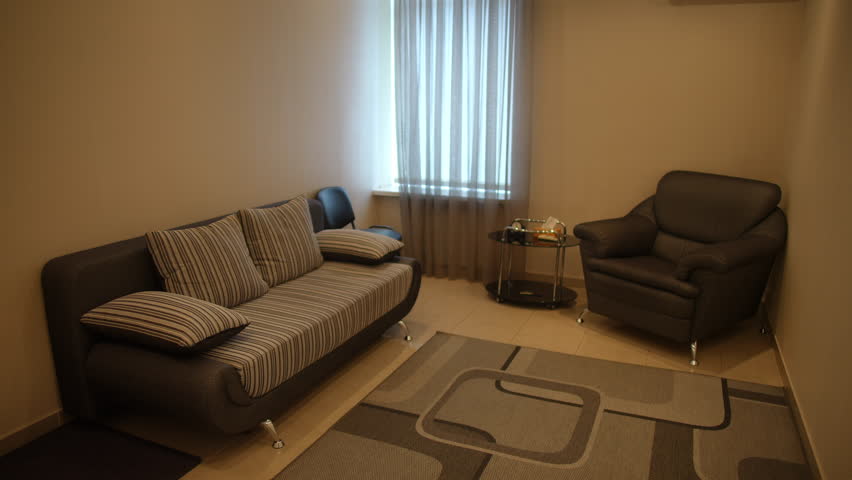 Modern interior of rest and relaxation room with sofa, armchair and coffee table