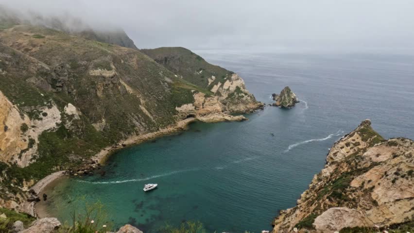 View of Potato Harbor - Santa Cruz Island, Channel Islands National Park off the coast of Southern California. Foggy view of the beautiful water, a boat is anchored in the harbor. 