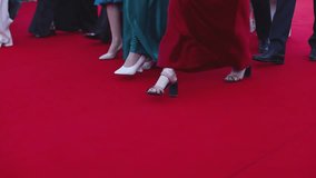 Red carpet with ropes and golden barriers on a luxury party entrance, cinema premiere film festival event award gala ceremony, wealthy rich guests arriving, outdoor decoration elements, summer day - Powered by Shutterstock - Get 15% off with code: PIKWIZARD15