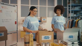 Female volunteers packing goods into donation boxes, giving high five, teamwork - Powered by Shutterstock - Get 15% off with code: PIKWIZARD15