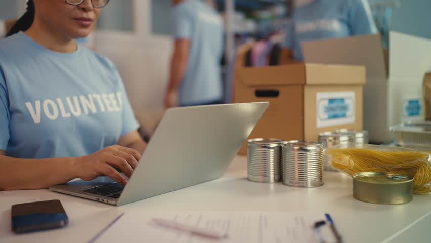 Multiethnic team of volunteers packing donated goods, organizing charity event
