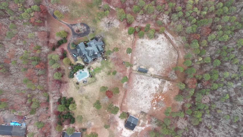 Top View Drone Shot of  a house in the middle of a field in the winter