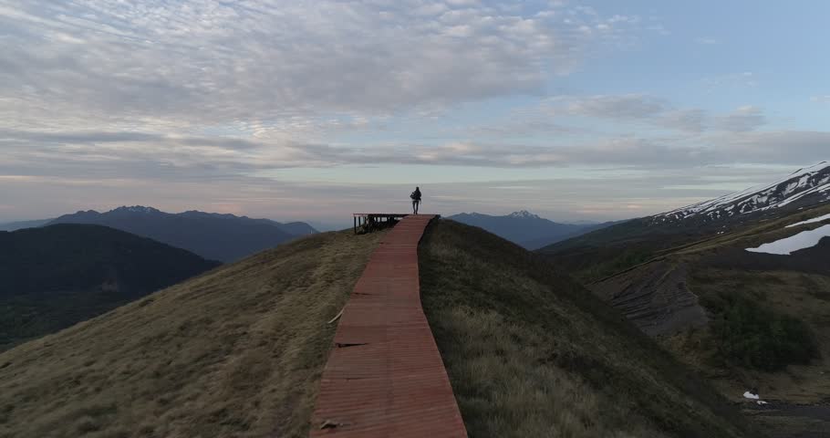 A man on a top of the mountain celebrating victory - concept of reaching goals