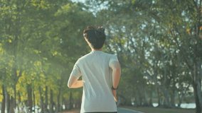 Attractive asian man jogging in the park on a background of trees with sunlight, Fitness Man Running, Training Run Workout. - Powered by Shutterstock - Get 15% off with code: PIKWIZARD15