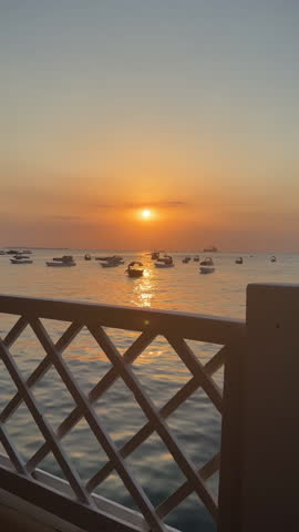 Travel, sea and water with boats by sunset for transportation, adventure and journey on vacation. Sky, dusk and ocean navigation in city of Zanzibar for tourism, outdoor voyage and seascape horizon.