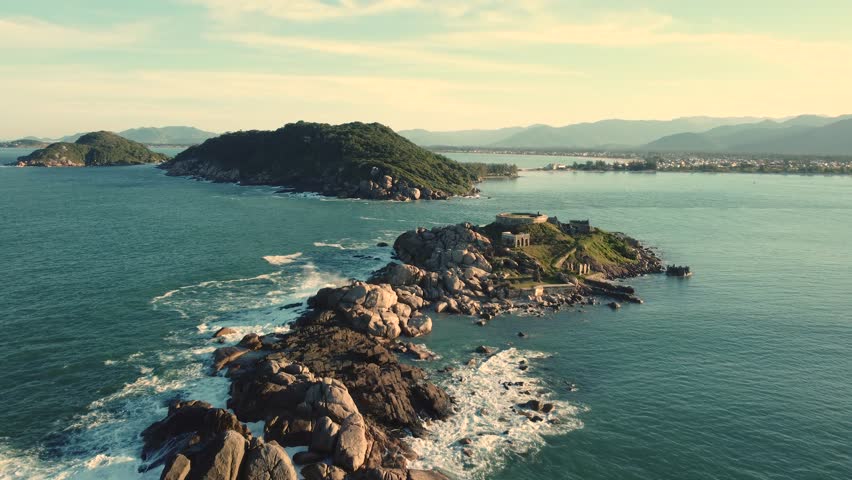 A drone view over rocky islands with a background of mountains