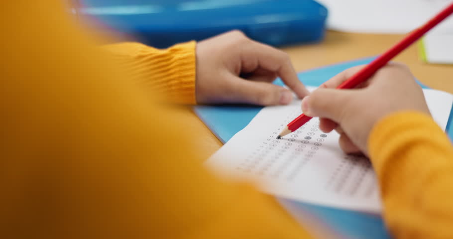 Education, hands and multiple choice with student at desk in classroom for assessment, development or learning. Exam, test or question and person in class with pencil to answer or select option