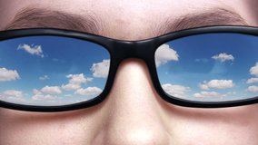 Eyes unrecognizable woman in glasses close up. Black frame glasses. Glass reflects the blue sky with clouds that run fast