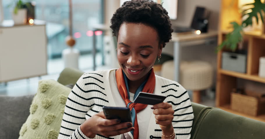 Credit card, phone and black woman on sofa in home with payment gateway checkout for online shopping. Relax, cellphone and African female person with internet bank app for debit transaction at house.