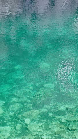 Blue transparent water in a mountain lake. Ripples on the surface of the water.