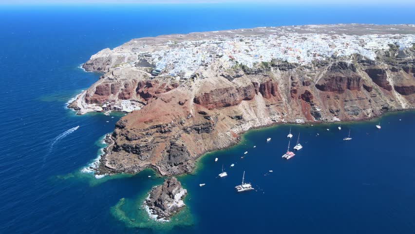 Flight around of Three Blue Domes church in Oia town on Santorini island, Greece
