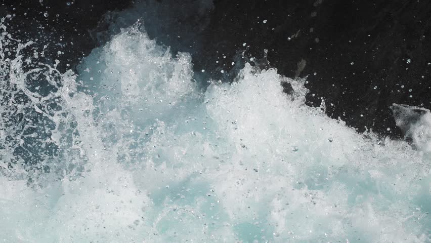 Dynamic shot of ocean waves crashing, with water splashing and foaming dramatically. Loop video.