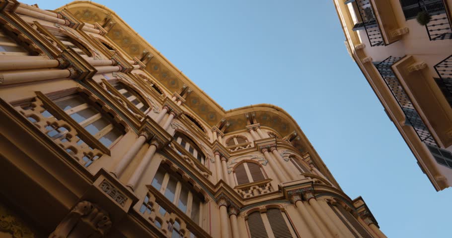 Looking up at ornate historic buildings in Palma de Mallorca, Spain, with clear blue skies above. Captures architectural beauty and European charm.