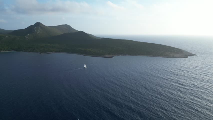 Sailboat passing island in Greece