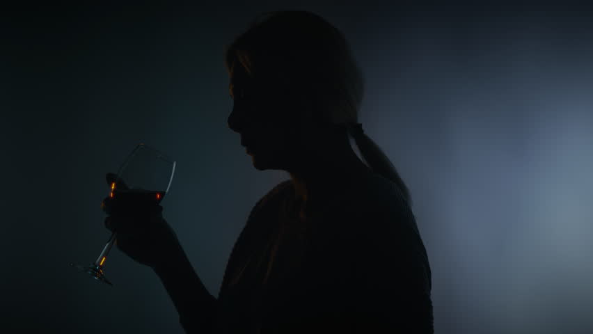 Sorrowful woman drinking alcohol from a glass, relationship crisis, solitude