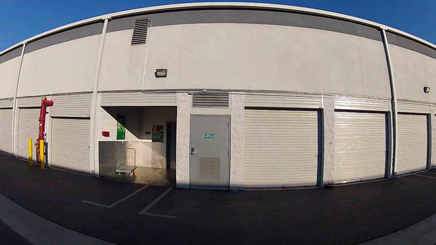 A car mounted camera rolls by clean and modern storage lockers or units at a public storage facility.