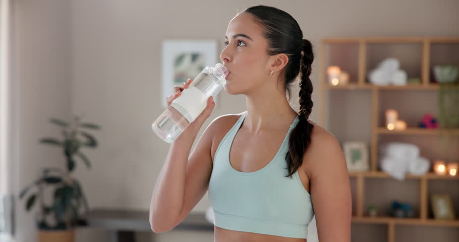 Home, woman and water for drinking after yoga, practice and relax with plastic bottle for wellness. Fitness class, female yogi and beverage as h2o liquid for thirst, hydration or health in house