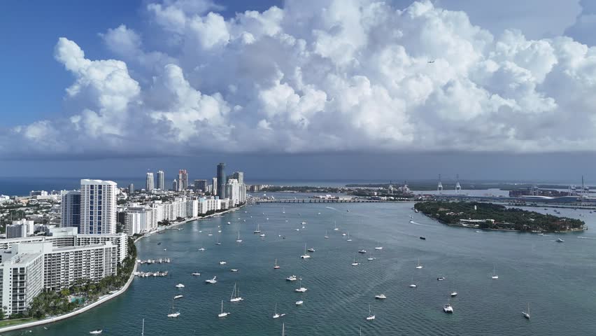 Aerial view of sand shore near turquoise sea in Miami Beach, resorts and apartment buildings in background at golden hour, Florida, USA