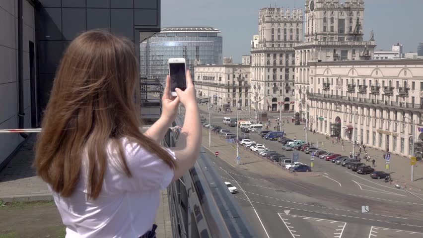 minsk belarus 05.05.2018 A woman is photographed on the towers of two famous buildings - the Gates of Minsk, Railway Station Square