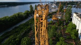 Dilapidated abandoned port cranes, dry dock and infrastructure at the Danube river port of Ruse in Bulgaria. Drone shot of graving dock with ship to shore cranes on the bank of a river. STS crane. - Powered by Shutterstock - Get 15% off with code: PIKWIZARD15