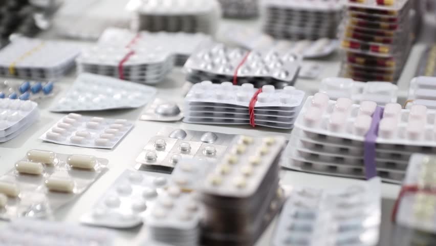 Pan shot over stacks of blisters full of medicine and pills of all kinds on a desk (HD)