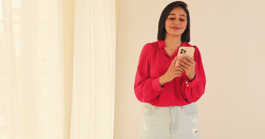 Smiling young woman using smartphone.