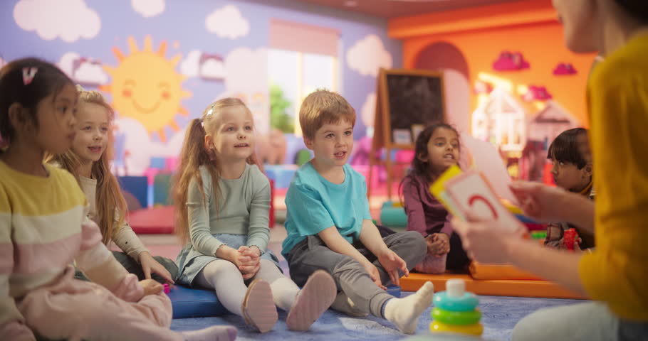 Cheerful Daycare Teacher Using Gaming and Acting Methods to Teach Multiethnic Kids Alphabet in Kindergarten. Small Cute Boys and Girls Getting Basic Reading and Writing Skills, Learning Alphabet