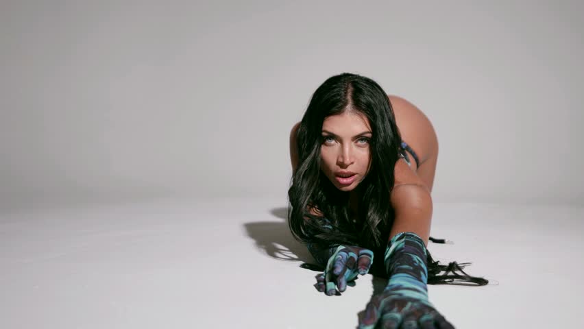A woman with expressive blue eyes and black hair in a suit with wings, in sexy underwear that elegantly emphasizes her magnificent forms.